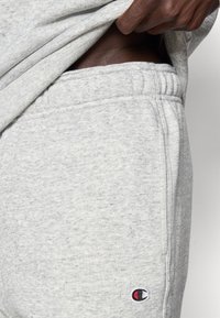 Γκρι βαμβακερές φόρμες με απαλό ύφασμα, ελαστική μέση και πλαϊνή τσέπη. Περιλαμβάνει μικρό πολύχρωμο κεντημένο λογότυπο.