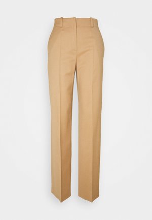 Pantalones beige de talle alto, confeccionados a medida, con trabillas para cinturón, corte de pierna recta y detalles de pliegue frontal.
