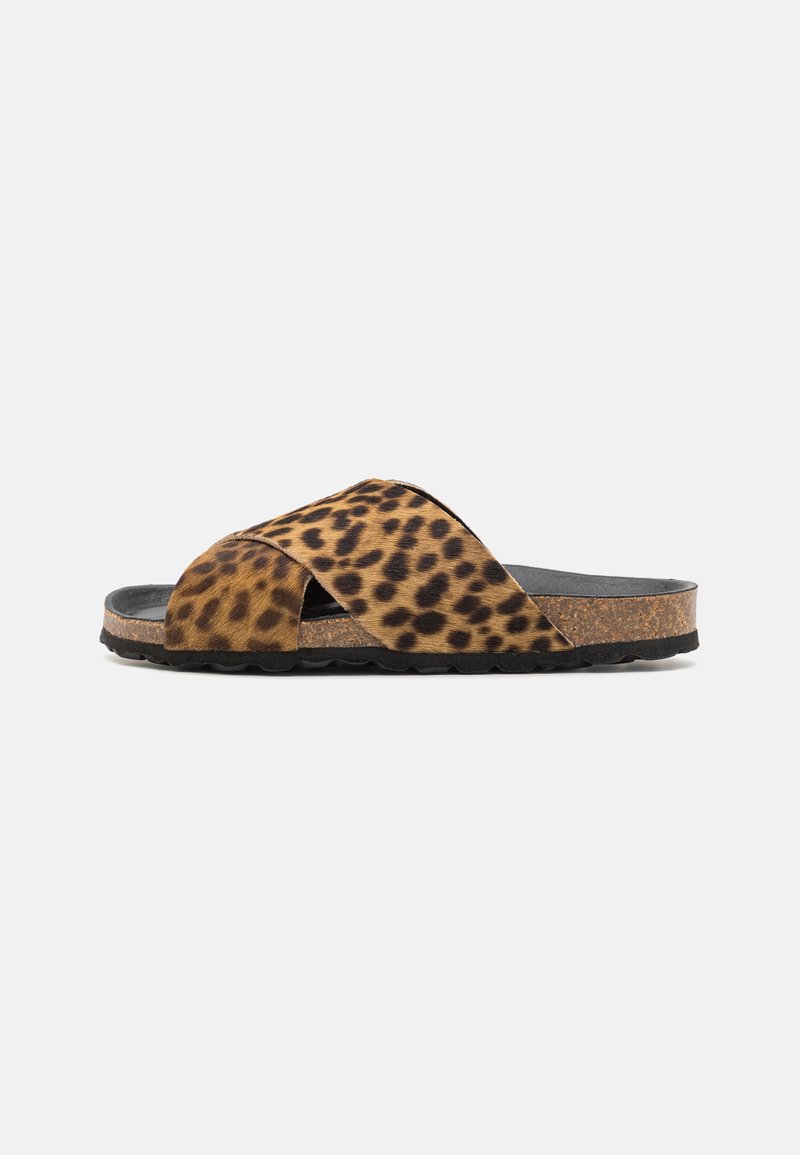 Leopard print slide sandal with cross straps, soft fur-like material, cork midsole, and textured rubber outsole for grip.