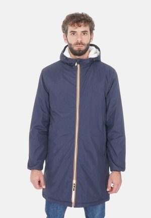 Cappotto isolato blu con cappuccio, foderato in pelliccia sintetica bianca, con zip frontale e dettagli a righe multicolore. Maniche lunghe e tasche incluse.