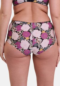 Bas de bikini taille haute en tissu noir orné de grands motifs floraux roses et violets. Finition avec des coutures décoratives le long des bords.
