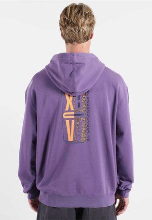 Sweat à capuche violet avec un grand motif graphique en orange et imprimé léopard dans le dos. Confectionné dans un tissu doux, avec une coupe décontractée et des poignets côtelés.