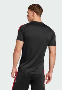 Black athletic shirt with short sleeves, featuring red accents on shoulders. Made from a smooth, lightweight fabric with a fitted design.