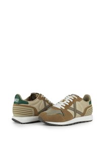 Beige and brown athletic shoes with mesh and suede materials, white laces, green accents, and a textured rubber sole.