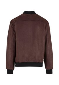 Jachetă bomber din suede maro, cu guler și manșete negre plisate. Prezentă un design simplu, cu o textură netedă și fără elemente metalice vizibile.