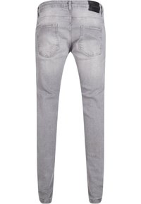 Harmaat farkut, joissa on slim fit -leikkaus, viisi taskua ja tekstuuri. Vyötäröllä musta nahkainen brändilappu.