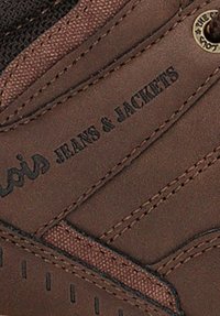 Zapatilla de cuero marrón con detalles texturizados, que presenta costuras negras y la marca "Lois Jeans & Jackets" en el lateral.
