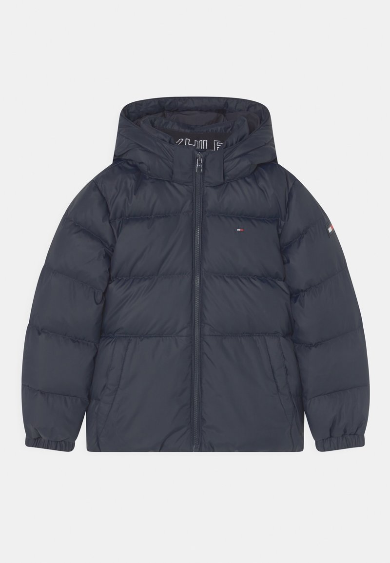 Geïsoleerde marineblauwe pufferjas met een capuchon, voorzien van een ritssluiting aan de voorkant, elastische cuffs en een logo-accent op de mouw.