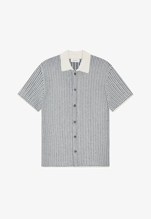 Lyhythihainen paita, jossa on teksturoitu laivastonsininen ja valkoinen kuvio, vaaleankermanvärinen kaulus ja ruskeat napit edessä.