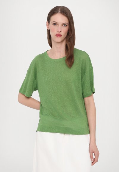 T-shirt verde a maniche corte realizzato in un tessuto leggero con scollo rotondo. Vestibilità rilassata e finitura del tessuto sottile e irregolare.