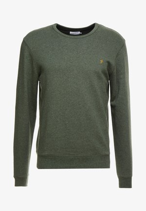 Vihreä collegepaita, joka on valmistettu pehmeästä kankaasta, jossa on pyöreä kaula-aukko, pitkät hihat, ribattu pääntie ja helma, sekä pieni keltainen brodeerattu logo.