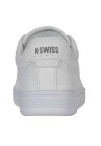 Fehér K-Swiss sportcipők textúrált bőr felsőrésszel, párnázott nyakkal és gumitalppal. Egyszerű dizájn és logó a saroknál.