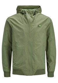 Giacca verde con zip e cappuccio, polsini e orlo elasticizzati, due tasche laterali e una piccola toppa con logo sulla parte superiore del petto. Tessuto leggero.