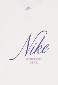 Biely bavlnený tričko s výrazným fialovým kurzívnym logom "Nike" a menším textom "ATHLETIC DEPT." v jednoduchom písme nižšie.