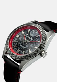 Edelstahlarmbanduhr mit einem schwarzen texturierten Armband, rotem Rahmen und schwarzem Ziffernblatt mit Friedenssymbolmustern und silbernen Stundenmarkierungen.