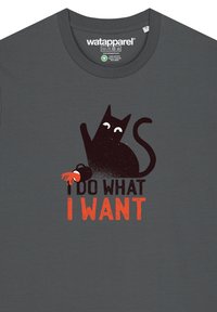 Donkergrijze t-shirt met een zwarte kat met witte ogen en een oranje klauw, bedrukt met de tekst "IK DOE WAT IK WIL" in oranje en zwart.