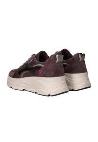 Une paire de baskets bordeaux et noires avec de grosses semelles blanches, des détails en daim et en maille, présentée de dos sur un fond blanc.
