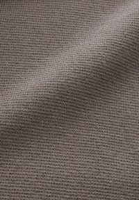 Beige, textured knit fabric with a uniform, tightly woven pattern, showcasing a smooth surface and subtle sheen.