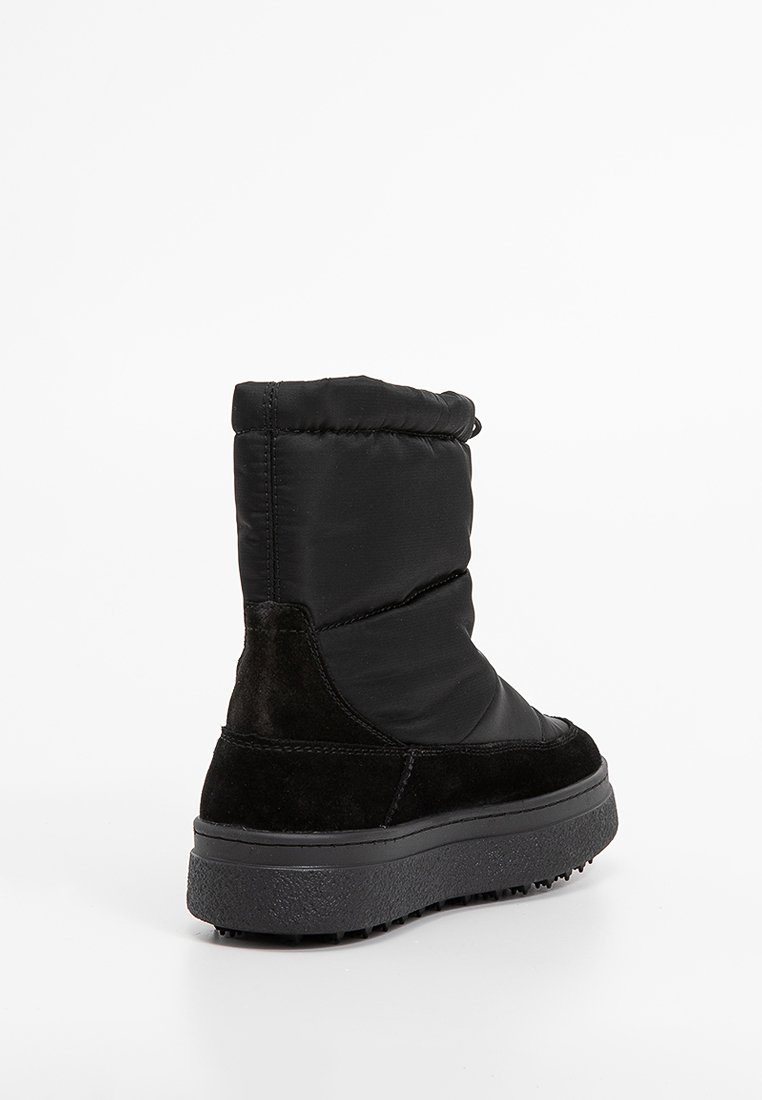 Botines negros con parte superior de nylon acolchado y acentos de ante. Presentan una suela de goma texturizada y un tacón ligeramente elevado.