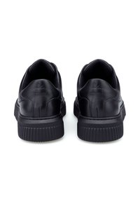 Sneaker nere in pelle con punta rotonda, colletto imbottito e suola in gomma testurizzata, con branding minimale sul tallone.