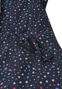 Schwarzer Stoff mit einem kleinen Blumenmuster in Pink, Blau und Weiß. Verfügt über eine aufgesetzte Tasche mit einem Klettverschluss und gestickten Details.