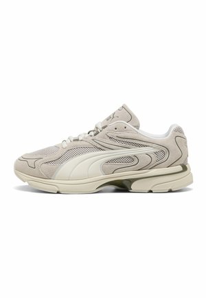 Baskets Puma beiges et blanches avec dessus en mesh et suède, semelle crème et bande classique Puma sur le côté, vues de l’extérieur.
