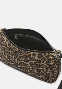 Clutch-Tasche aus Stoff mit Leopardenmuster, mit einem Reißverschluss geöffnet, bietet eine glatte Oberfläche und ein schwarzes Innenfutter mit zusätzlichem Reißverschlussfach.