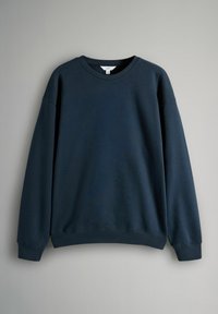 Sudadera de color azul marino con cuello redondo, corte relajado, hombros caídos y puños y dobladillo acanalados. Confeccionada en una suave mezcla de algodón.