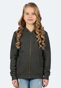 Felpa grigia con zip, realizzata in materiale morbido, con zip frontale, due tasche anteriori e cappuccio. Abbinata a jeans azzurri chiari.