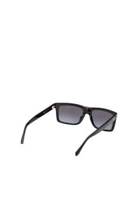 Czarne okulary przeciwsłoneczne w kwadratowej oprawie, z gradientowymi ciemnoszarymi soczewkami i teksturowanymi czarnymi zausznikami. Zawierają subtelny detal logo po boku.