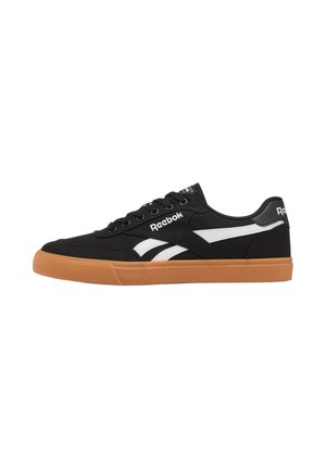 Zwarte Reebok sneaker met lage schacht, witte zijstrepen, gum rubberen zool en zwarte veters, zijaanzicht op witte achtergrond.