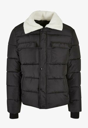 Geacă pufoasă neagră, cu un guler texturat din fleece alb, nasturi pe față și două buzunare cu clapetă pe piept.