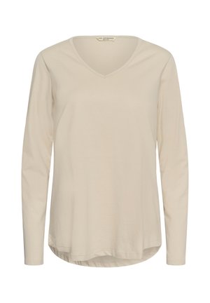 Beige V-hals shirt met lange mouwen en een licht gebogen zoom, voorkant weergegeven tegen een effen achtergrond.