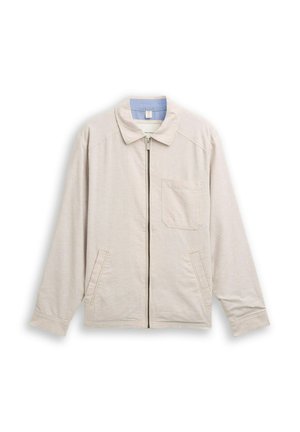 Béžová bunda na zips s golierom, náprsným vreckom a dvoma prednými vreckami, položená na bielom pozadí.