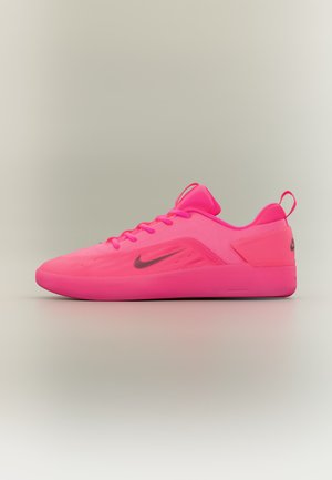 Ярко розов нисък спортен маратонка с черно лого Nike Swoosh, горна част от мрежа и дръжка на петата, показан в страничен профил на неутрален фон.
