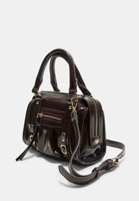 Ciemnobrązowa torebka ze skóry lakierowanej z dwoma uchwytami, jedną regulowaną rączką i złotymi dodatkami. Posiada przednie kieszenie na zamek oraz szwy ozdobne.