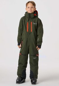 Grön snöoverall med orange detaljer, har dragkedja framtill, flera fickor och svarta textildetaljer vid anklar och muddar.