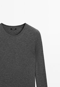 Grauer, gerippter Pullover mit Rundhalsausschnitt. Das Material wirkt weich und strukturiert, hat ein einfaches Design und lange Ärmel. Etikett sichtbar innen.