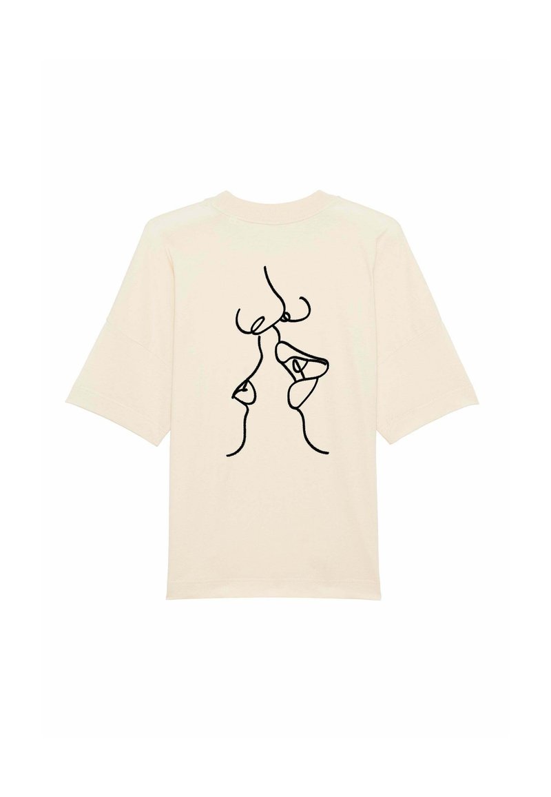 Krémové tričko z měkké látky, s černým kresleným vzorem abstraktních tváří na zadní straně. Volný střih s krátkými rukávy.