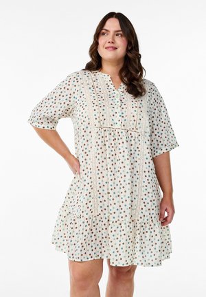 Weißes Kleid mit kurzen Ärmeln, mehrfarbigen Punkten, V-Ausschnitt, Spitzenakzenten und einem ausgestellten Saum. Hergestellt aus leichtem Stoff.