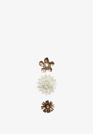Trois accessoires floraux : une fleur en ton doré avec un centre en cristal, une fleur blanche en couches et une fleur en bronze avec un accent en cristal.