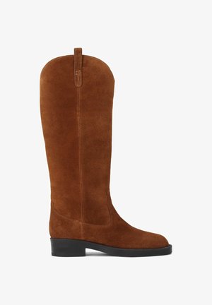 Brūni zamšaini zābaki līdz ceļiem ar noapaļu purngalu, zemu melnu papēdi un cilpu aizmugurē. Gluda tekstūra un tīrs, vienkāršs dizains.