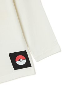 Weißes Langarmshirt mit einem schwarzen Patch, der ein rot-weißes Pokémon-Ball-Design zeigt, mit sichtbaren Nähten gestickt.
