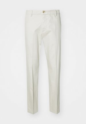 Pantaloni beige chiaro realizzati in tessuto morbido e testurizzato. Presentano una chiusura con bottone, passanti per cintura e gambe dritte. Design pulito e su misura.