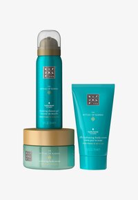 Ritual of Karma Set: schäumendes Duschgel (50 ml, türkise Flasche), Körpercreme (70 ml, türkise Tube) und Körperpeeling (250 ml, runder Tiegel, goldener Deckel).