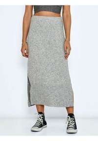Jupe maxi en tricot gris avec une fente sur le côté, fabriquée en tissu doux, associée à des baskets montantes noires. Design simple et fonctionnel.