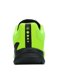 Neon gele sportschoen met een zwarte basis, met een gladde textuur, verstevigde hiel en drie zwarte decoratieve stippen op de achterkant.