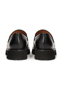 Black leather shoes with a sleek design, featuring rounded toes and thick black rubber soles. The back heel has a smooth finish.