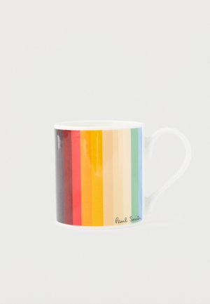 Valkoinen keramiikkamuki, jossa pystysuorat sateenkaaren raidat ja kaareva kahva, sekä "Paul Smith" -allekirjoitus lähellä pohjaa.