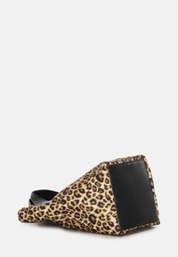 Scarpa in tessuto animalier con stampa leopardata, con un accento in pelle nera sul tallone, caratterizzata da una forma a zeppa unica e una superficie testurizzata.